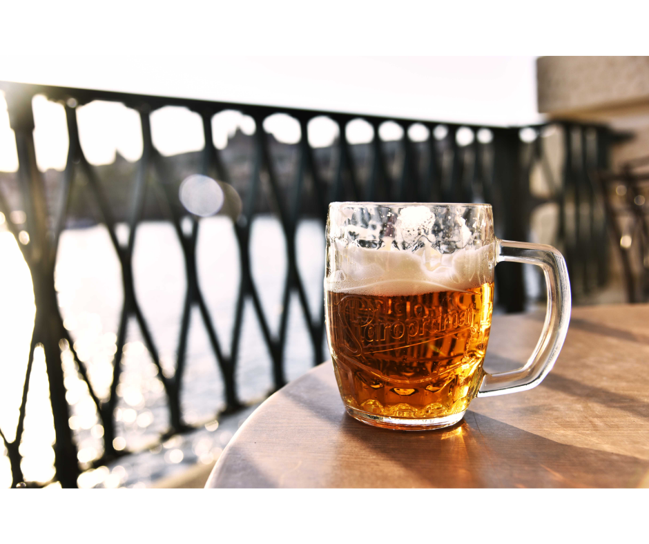 A pint of beer on a table overlooking a river