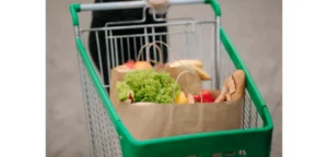 Shopping trolley containing bags of fruit and vegetables