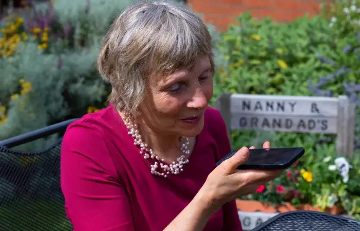 A photo of a grey haired lady speaking to In Your Pocket, while sitting in the garden