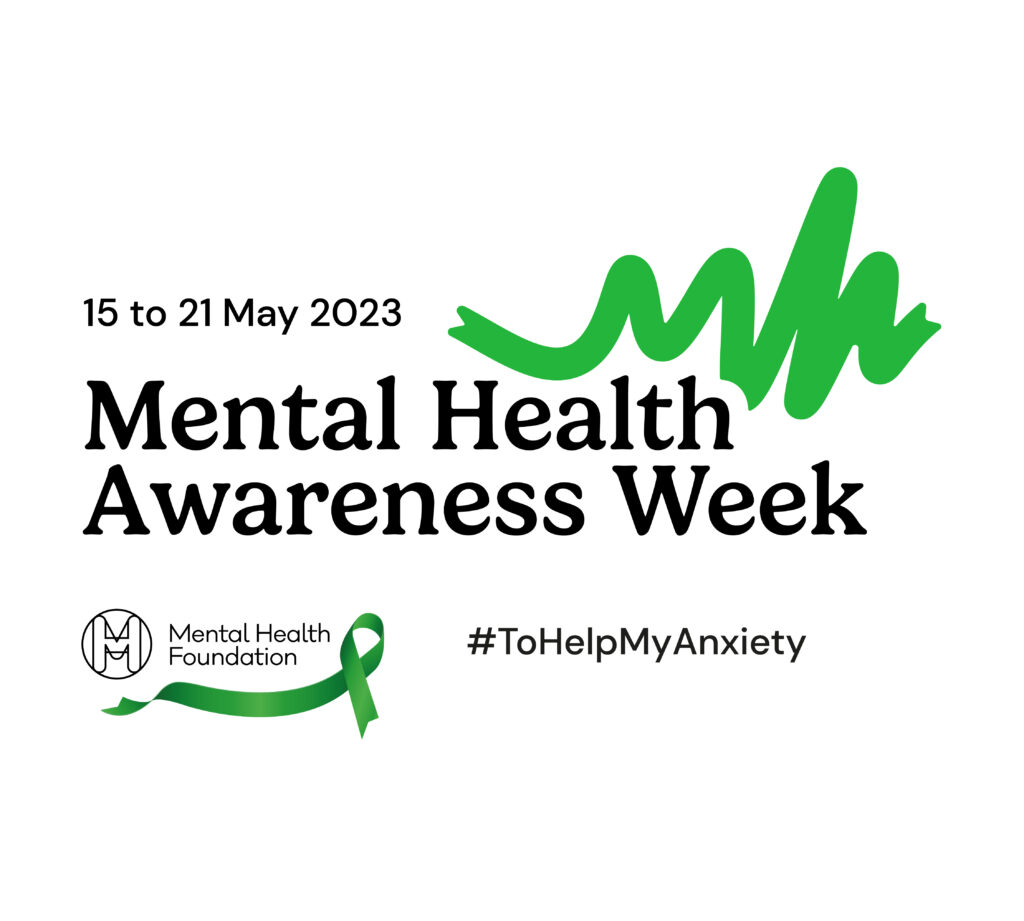 The logo that spells out Mental Health Awareness Week 15 to 21 May. The logo has black writing and features green ribbons