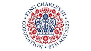 Image of the logo to mark the Coronation of King Charles III on 6th May 2023. The logo features a crown in navy blue surrounded by a ring of red flowers
