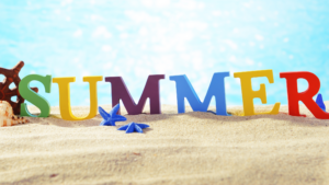 The word summer is spelt out in different coloured letters on a beach with a blue sky