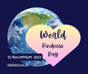 ‘World Kindness Day’ written in bold cursive on a gradient light yellow and pink heart. The background is dark navy blue. On the left behind the heart is Earth. On the lower left it says, ’13 November 2023’ and the link realsam.co.uk.
