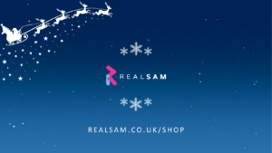 Image of the real sam logo on a starry night blue background with white reindeer in the top left corner and the website address www.realsam.co.uk on the bottom