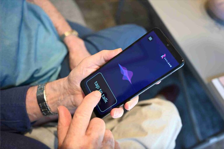 Person tapping the 'Tap to Talk' button on a RealSAM Phone screen