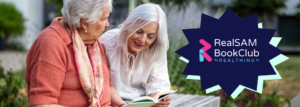 Two ladies sitting on a park bench with the logo for Real Sam bookclub on their right